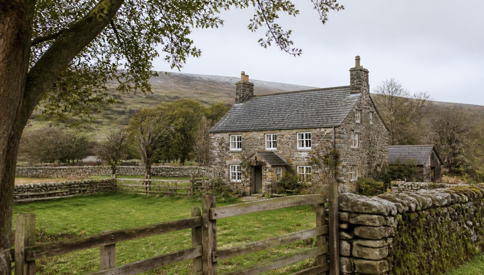 Stone smallholding farmhouse with small fenced paddocks and a dry stone wall